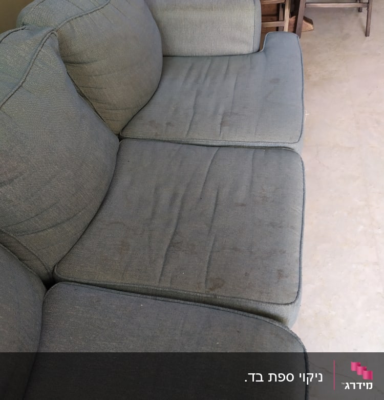 ספה אפורה עם כתמים על המושב